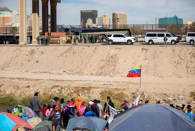Migrants standing near the Rio Grande in Juárez, Mexico look on as Congressman Kevin McCarthy and GOP Leader in the U.S. House of Representatives and other members of the GOP tour the makeshift migrant processing center near the Rio Grande on Tuesday, Nov. 22, 2022, in El Paso.