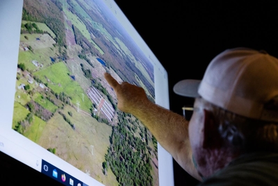 Gary Boren points to an aerial photo of a Battery Energy Storage System (BESS) as he and his wife express their concerns regarding solar project expansions in their county, at a community meeting at Penelope's Coffee in Mt. Vernon, on April 8, 2023. A BESS enables energy from renewables to be stored and later released.