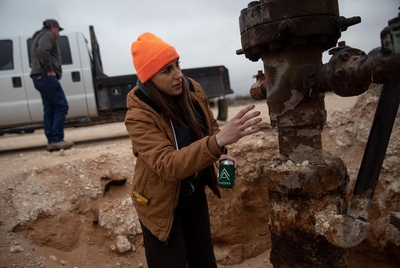 Sarah Stogner, an oil and gas attorney, inspects a leaky, old oil well on the Antina Cattle Company ranch in February 2023.