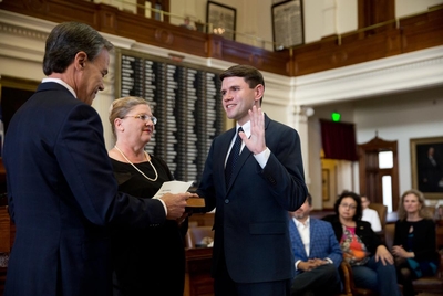 Speaker Joe Straus swears in Rep. James Tamarico as Talarico's mother Tamara, holds a bible on  Nov. 20, 2018