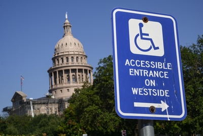 A sign guiding pedestrians to accessible entrances is seen outside Capitol grounds Tuesday, Sept. 19, 2023 in Austin.