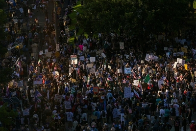 Demonstrators gather outside of the Texas Capitol grounds during Austin's "No Kings" protest on June 14, 2025, in Austin, Texas.