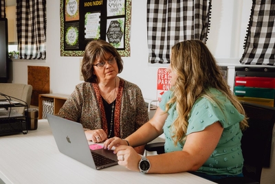THROCKMORTON, TEXAS — JULY 29, 2025: Gay Hibbitts, 57, educator, left, speaks with her mentor, Amy Dick, 34, secondary social studies teacher at Throckmorton Collegiate ISD,  inside a classroom at Throckmorton Collegiate ISD in Throckmorton, Texas, on Tuesday, July 29, 2025. Ms. Hibbitts was part of a federally funded educator preparation program serving about 30 participants across 11 rural Texas districts. The funding, which covered two years of college and training costs, was cut on April 25 under the