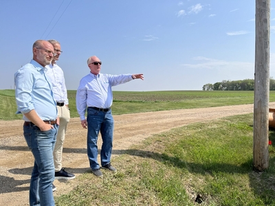 Golden West CEO Denny Law, right, shows Federal Communications Commissioner Brendan Carr, left, and Sen. John Thune, R-South Dakota, a broadband expansion site near Colton in May 2023. (Joshua Haiar/South Dakota Searchlight)