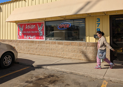 A woman leaves an Asian market in Huron. (John Hult/South Dakota Searchlight)