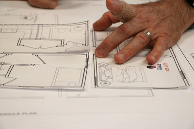 Manning-Beavin's hand rests on the paper shapes of "boxes" at the table. (Kentucky Lantern photo by Liam Niemeyer)