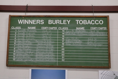 A chalkboard showing the tobacco contest winners.