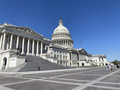 The U.S. Capitol, with a rotunda and wings for the U.S. House and the U.S. Senate, silhouetted against a clear blue sky.