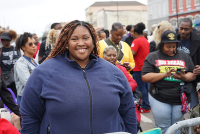 A teen girl poses for a photo in front of a crowd