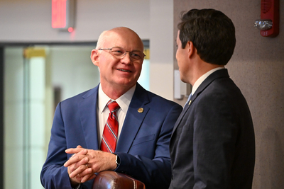 Two men in suits talking.