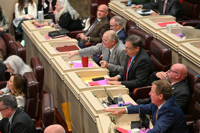 Men in suits sitting in desks.