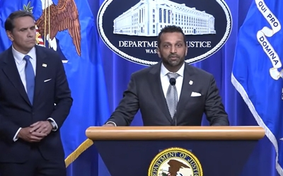 A man in a suit at a lectern with a man in a suit standing to his right