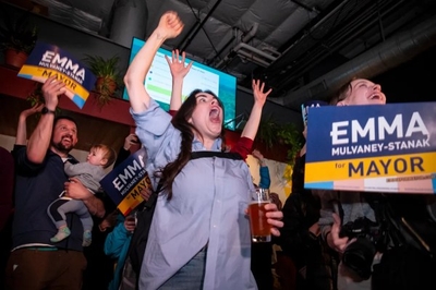 A woman with her arms up and a crowd of people.