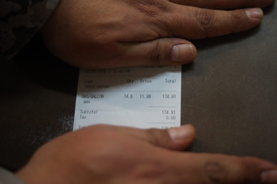 A customer at a store in Iliamna shows a receipt for a gas purchase Monday. (Nathaniel Herz/Anchorage Press)