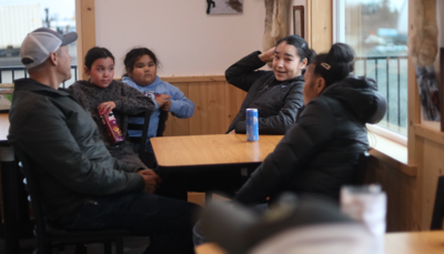 Jessie Wilson, center, chats with Bill Hill in Iliamna. (Nathaniel Herz/Anchorage Press)