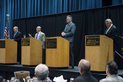 Democratic candidate Les Gara, second from left, speaks at an Oct. 11 gubernatorial candidate forum held by the Resource Development Council for Alaska. Other candidate are, from left, former Gov. Bill Walker, an independent, Gov. Mike Dunleavy, the Republican incumbent, and Republican Charlie Pierce. Candidates this elextion season, partiularly Gara and Walker, have spent a lot of time at public events talking about outmigration of young Alaskans. (Photo by Yereth Rosen/Alaska Beacon)