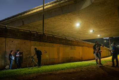 Three people who stay under this Moanalua Freeway onramp come out through a small door after being interviewed by IHS staff during the Point In Time homeless count Monday, Jan. 26, 2026, in Honolulu. (Kevin Fujii/Civil Beat/2026)