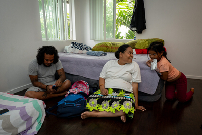 Erty Sernus, 38, center, speaking with her daughter, Ella, 7, as her husband, J. D. Ready, 36, looks at his phone in their Family Promise studio in Wahiawa. The family has three months of housing now but spent months living in a park.
