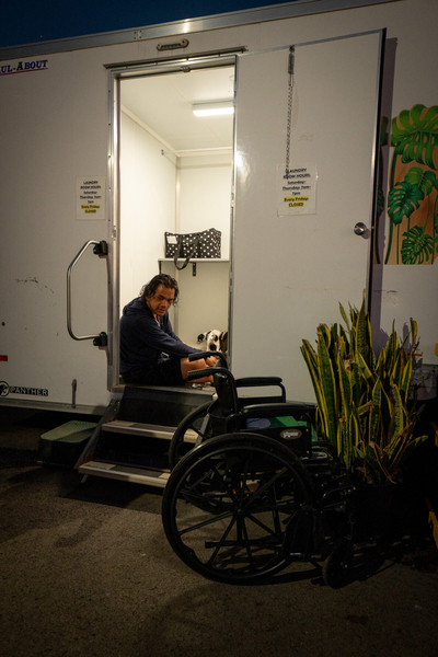 Kaisa Tai (cq) waits for his laundry to finish in the doorway of the laundry facilities at Ho'okahi Leo Kauhale. His wheelchair sits outside the structure.