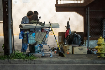 Two men next to a shopping cart at the corner of Vineyard and Liliha.
