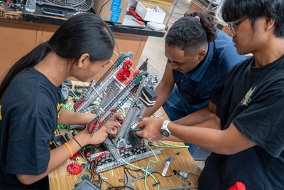 From left: Kelson Chase Buentipo, Zion Soumwei and Erixon Fulgencio at work on their robot at Nānākuli High &amp; Intermediate School June 29, 2026. (Craig Fujii/Civil Beat/2026)