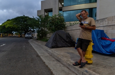 Shannon Elwood outside his tent along Sand Island Parkway August 14, 2026. Ronnie Jaralba died in a tent near the same location. "I haven't seen Ronnie in a long time," he said. (Craig Fujii/Civil Beat/2026)