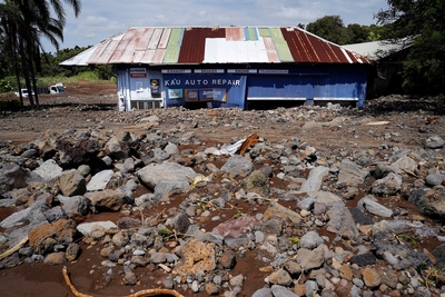 Kaʻū Auto Repair sits buried in rubble washed down from the Nāʻālehu Cemetery Tuesday, Aug. 18, 2026, on Hawaiʻi Island. Hurricane Lala made a close pass to the South Point of the Big Island Saturday. (Kevin Fujii/Civil Beat/2026)