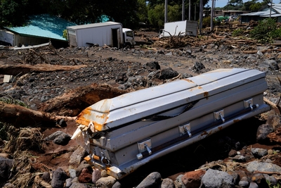 A casket washed down from Nāʻālehu Cemetery lies among rubble Tuesday, Aug. 18, 2026, on Hawaiʻi Island. Hurricane Lala made a close pass to the South Point of the Big Island Saturday. (Kevin Fujii/Civil Beat/2026)