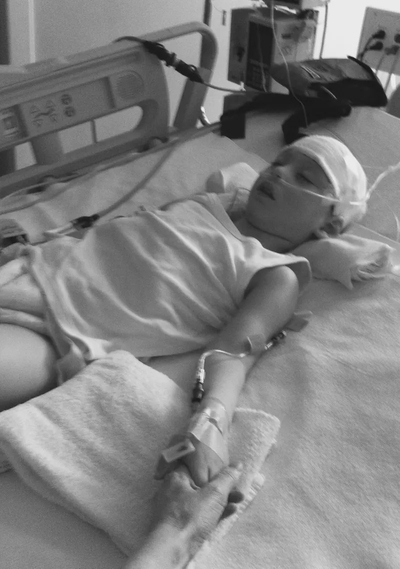 Ysadore Maklakoff holds the hand of his mother, Alessandra Fabrello, during a stay at the hospital