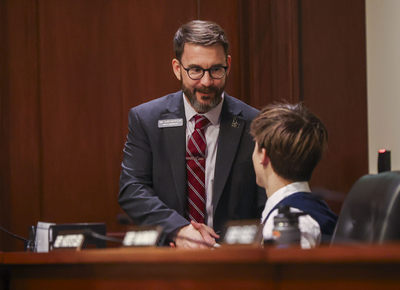 Rep. Clint Hostetler, R-Twin Falls, shakes the hand of a House page the House Education Committee meeting