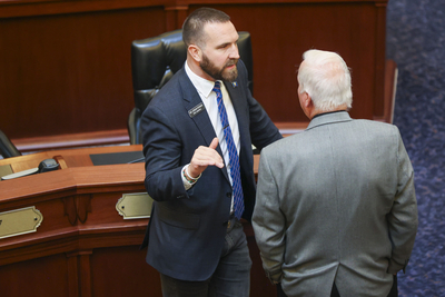 Rep. Jordan Redman, R-Coeur d'Alene, chats with a colleague on Idaho House of Representatives floor