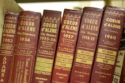 A few Polk's Directories, red leatherbound books chronicling community residents, for the city of Coeur d'Alene sit on a shelf in the Idaho State Historical Society.