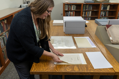 Idaho State Historical Society Outreach and Collections Archivist Angie Davis thumbs through the Idaho Organic Act, an 1863 congressional bill that established a territorial government for Idaho.