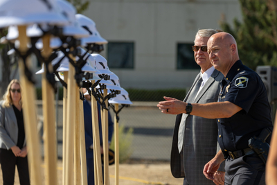 Idaho State Police’s director, Col. Bill Gardiner, reached toward a shovel at a groundbreaking ceremony next to Gov. Brad Little.