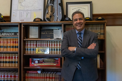 Idaho Attorney General Raúl Labrador poses in his office near a golden fiddle he received as a gift after legal victories that his office described as defeating Satan on Oct. 13, 2026.