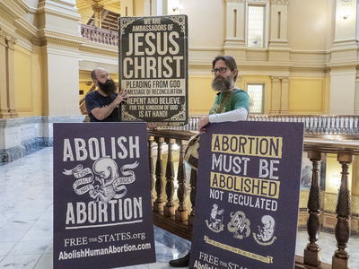 Anti-abortion protestors hold signs