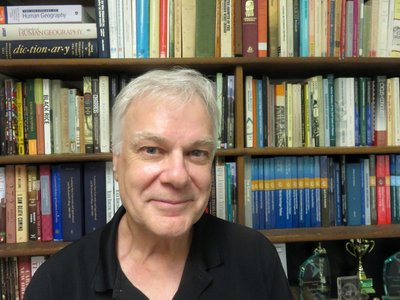 LSU Professor Andrew Sluyter is pictured in his office, seated in front of a bookcase
