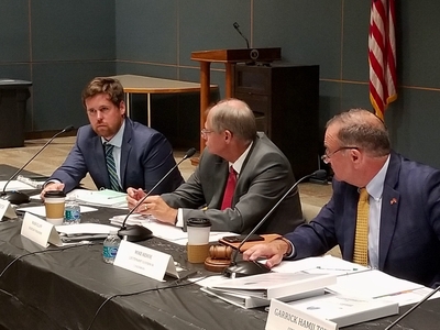 Three members of the Missouri Housing Development Commission, all white men in suits, are showing discussing a policy issue during the Sept. 1, 2021, commission meeting.