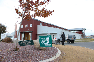 Signs supporting and opposing CI-128 in front of the Lewis and Clark County Fairgrounds polling location on Nov. 5, 2024. (Photo by Blair Miller, Daily Montanan)
