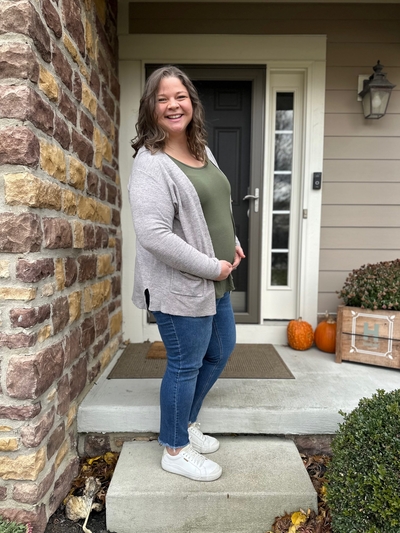 Sarah Hanline stands on a step holding her pregnant belly.