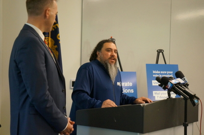 Daniel Cortez (center), president of the Oregon chapter of the American Postal Workers Union, joined Oregon Secretary of State Tobias Read at a news conference in Portland on Oct. 13, 2026 to encourage Oregonians to get ballots in the mail at least a week in advance of the Nov. 3. elections. (Photo by Alex Baumhardt/Oregon Capital Chronicle)