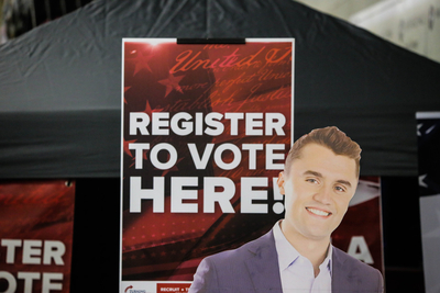 A voter registration booth features a cardboard cutout of the late Charlie Kirk at the NRA's Great American Outdoor Show at the Farm Show complex in Harrisburg, on Feb. 11, 2026. (Photo by Tim Lambert/Pennsylvania Capital-Star)