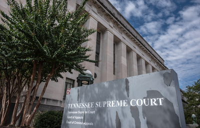 An official-looking building with columns and a sign in front saying "Tennessee Supreme Court."
