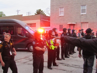 Protesters confronting riot-clad officers on the first day. Officers were blocking side streets. (Photo by Isiah Holmes)