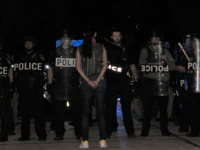 Kimberly Motley, one of the lawyers representing the families of those Officer Joseph Mensah has killed, confonts the numerous officers clad in riot gear in Wauwatosa the evening of August 14th, 2020. (Photo by Isiah Holmes)