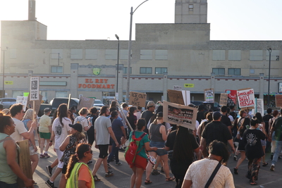Protesters march by the El Ray foods where Reyna Elizabeth Garcia was arrested along with her fiance and brother on Sunday. (Photo by Isiah Holmes/Wisconsin Examiner)