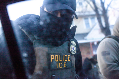 A masked U.S. Immigration and Customs Enforcement agent knocks on a car window in Minnesota on Jan. 12, 2026. (Photo by Nicole Neri/Minnesota Reformer)
