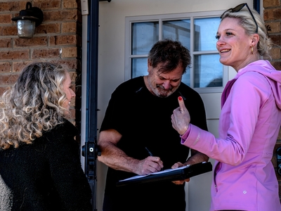 House District 75 Democratic candidate Allie Phillips, left, collects a signature for her ballot petition with her friend Kathryn Rickmeyer, right, who has also had to leave the state to receive an abortion. (Photo by John Partipilo/Tennessee Lookout)