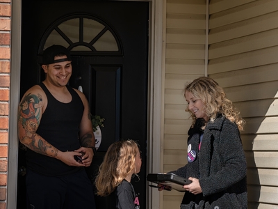 ouse District 75 Democratic candidate Allie Phillips receives a signature for her ballot petition from neighbor Tyler Dupont, who supports former Republican President Donald Trump, with her 6-year-old daughter. (Photo by John Partipilo/Tennessee Lookout)