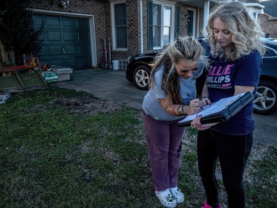House District 75 Democratic candidate Allie Phillips receives a signature for her ballot petition from neighbor Amber Johnson. (Photo by John Partipilo/Tennessee Lookout)